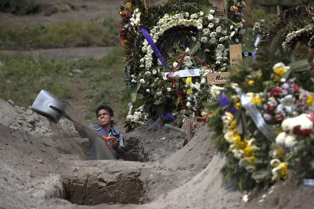 A cemetery worker digs a grave in a section of the Valle de Chalco Municipal Cemetery which opened early in the coronavirus pandemic to accommodate the surge in deaths, on the outskirts of Mexico City, Thursday, September 24, 2020. (Photo by Rebecca Blackwell/AP Photo)