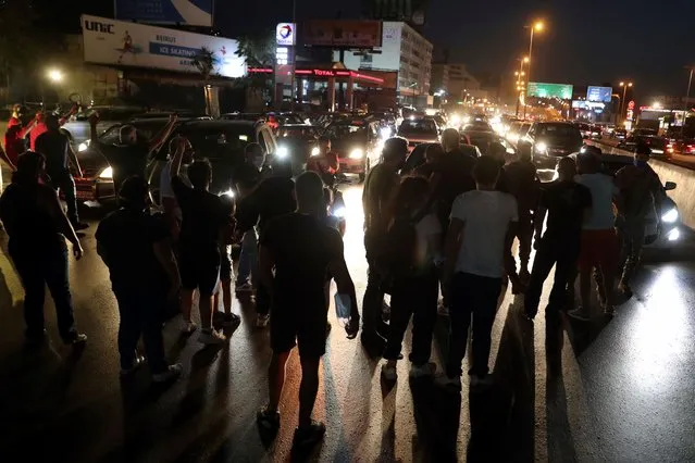 Anti-government protesters block a main highway during a demonstration against deteriorating economic conditions as politicians are deadlocked over forming a new government, in the town of Jal el-Dib, north of Beirut, Lebanon, Sunday, September 27, 2020. Lebanese Prime Minister-designate Mustapha Adib resigned Saturday amid a political impasse over government formation, dealing a blow to French President Emmanuel Macron's efforts to break a dangerous stalemate in the crisis-hit country. (Photo by Bilal Hussein/AP Photo)