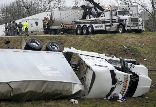 Officials investigate an accident involving 18-wheelers on SH 130 south of Texas 71, in Austin, Texas, during an ice storm on Tuesday January 31, 2023.  Winter weather is bringing ice to a wide swath of the United States, causing the cancellation of more than 1,600 flights nationwide and knocking out power to thousands of Texans. (Photo by Jerry Larson/Waco Tribune-Herald via AP Photo)