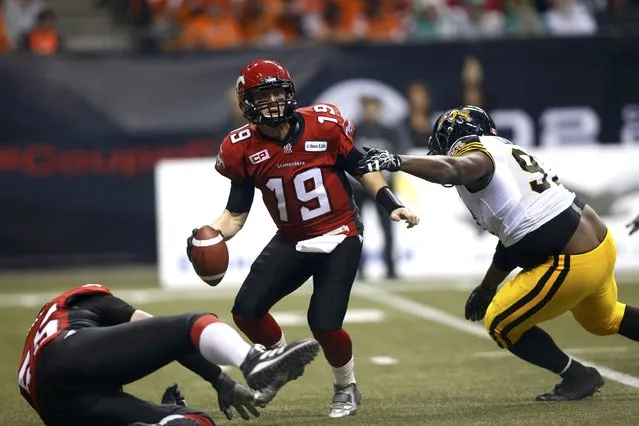 Calgary Stampeders' quarterback Bo Levi Mitchell scrambles while under pressure by Hamilton Tiger Cats' Ted Laurent in the first half during the CFL's 102nd Grey Cup football championship in Vancouver, British Columbia, November 30, 2014. (Photo by Ben Nelms/Reuters)