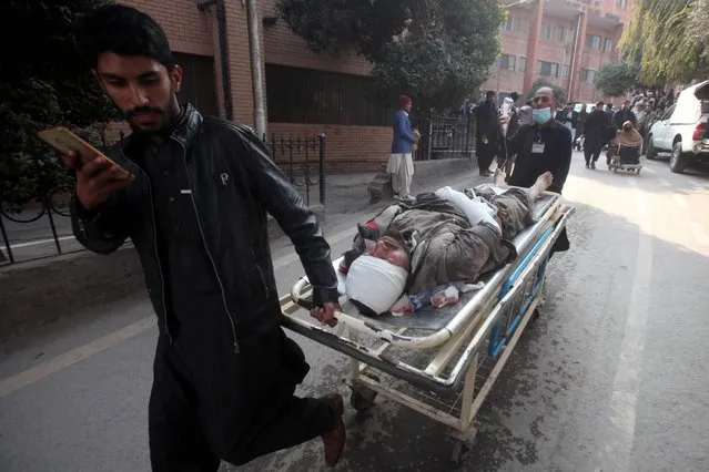People push a stretcher carrying an injured victim after a mosque blast inside the police headquarters, at a hospital in Peshawar on January 30, 2023. A blast at a mosque inside a police headquarters in Pakistan on January 30 killed at least 25 worshippers and wounded 120 more, officials said. (Photo by Zafar Iqbal/AFP Photo)
