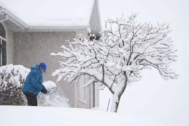 A person shovels their sidewalk in Provo, Utah, on February 22, 2023. Powerful winter storms lashed the United States on Wednesday, with heavy snow snarling travel across wide areas, even as unusual warmth was expected in others. Blizzards expected to dump up to two feet (60 centimeters) of snow swept across a vast band of the country from the West Coast to the Great Lakes, grounding flights and knocking out power to tens of thousands. (Photo by George Frey/AFP Photo)
