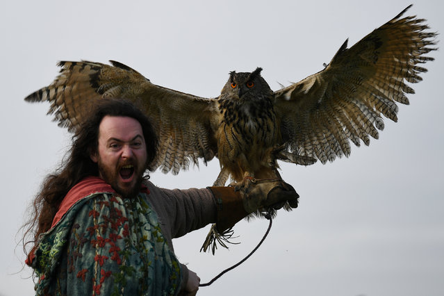 Druid Malachy, played by Ciaron Davies, reacts with a European eagle-owl named “Cracker” during the re-enactment of the first landing of Saint Patrick in Ireland at Inch Abbey in Downpatrick, Northern Ireland, March 11, 2018. (Photo by Clodagh Kilcoyne/Reuters)