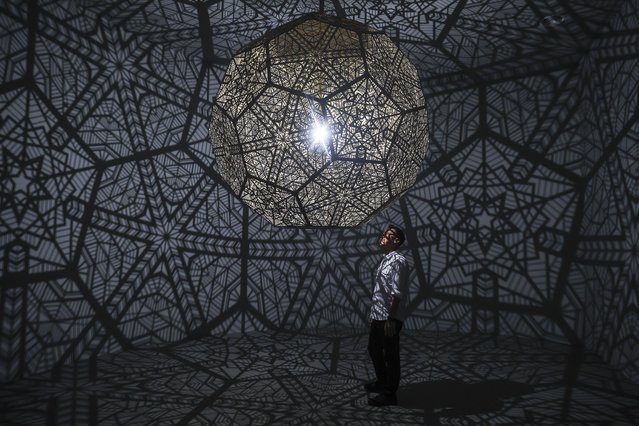 A man looks at the projection mapping and interactive installation known as “Prism Shine” inside the multi-dimensional media art gallery Immersify KL in Kuala Lumpur, Malaysia, 04 March 2025. Immersify KL attracts visitors with interactive installations, high-definition visuals, and 3D spatial sound, creating breathtaking zones, including the country’s first 360-degree, 12-meter-high projection space inside a 30,000-square-foot area with 11 sections of different immersive zones. (Photo by Fazry Ismail/EPA)