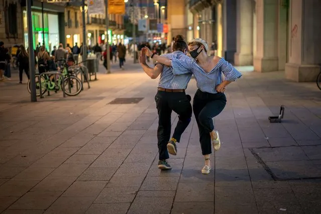 Professional dancer Sandy Lewis, from Louisiana, performs with his dance partner Marti Gasol, as they train in the street due to restrictions to do it indoor, in Barcelona on Wednesday, November 11, 2020 as Spain continue with new measures against the COVID-19. (Photo by Emilio Morenatti/AP Photo)