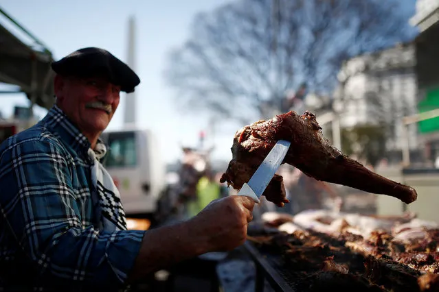 A man holds a piece of grilled meat at the Argentina's leading “asadores” roasting competition in Buenos Aires, Argentina, October 9, 2016. (Photo by Agustin Marcarian/Reuters)