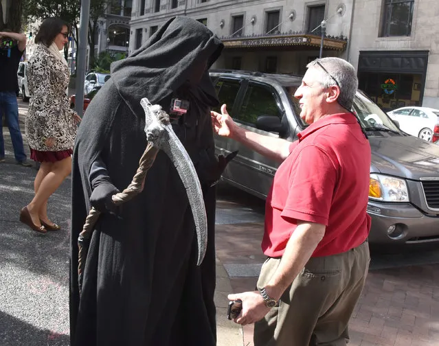 In an October 10, 2016 photo, the “Grim Reaper” meets Mark Caparelli , of Whithall, Pa., during his lunch break along Grant Street in Pittsburgh. Mark was not using his cell phone. (Photo by Darrell Sapp/Pittsburgh Post-Gazette via AP Photo)