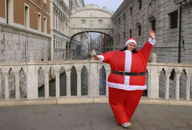 A woman dressed as Santa Claus poses in front of the Bridge of Sighs in Venice December 21, 2014. (Photo by Manuel Silvestri/Reuters)