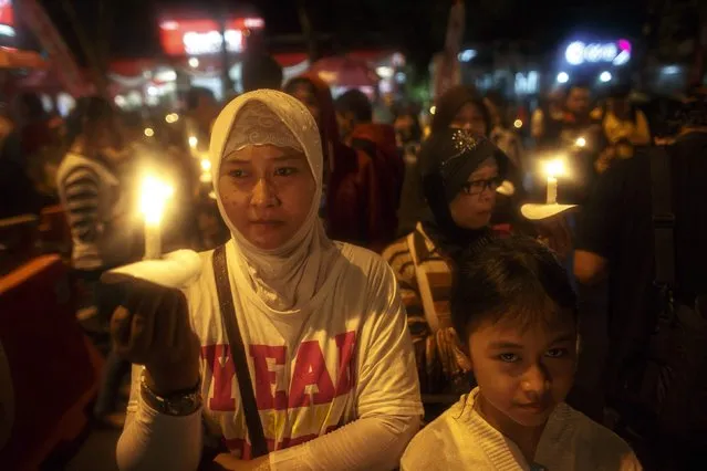 Indonesians hold up candles during a candle light vigil for the victims of AirAsia flight QZ8501 at Surabaya December 31, 2014. (Photo by Athit Perawongmetha/Reuters)