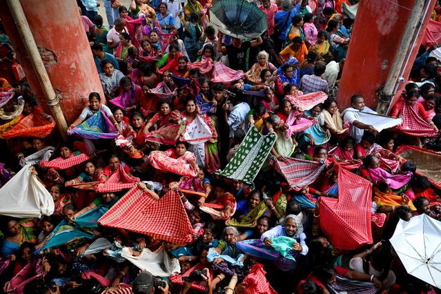 Hindu devotees collect rice offerings distributed on the occasion of 'Annakut' or 'Govardhan Puja' festival at the Madan Mohan temple in Kolkata on October 22, 2025. (Photo by Dibyangshu Sarkar/AFP Photo)