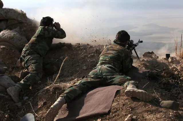 A Kurdish peshmerga fighter shoots during an operation to attack Islamic State militants in the town of Naweran, near Mosul, October 23, 2016. (Photo by Azad Lashkari/Reuters)