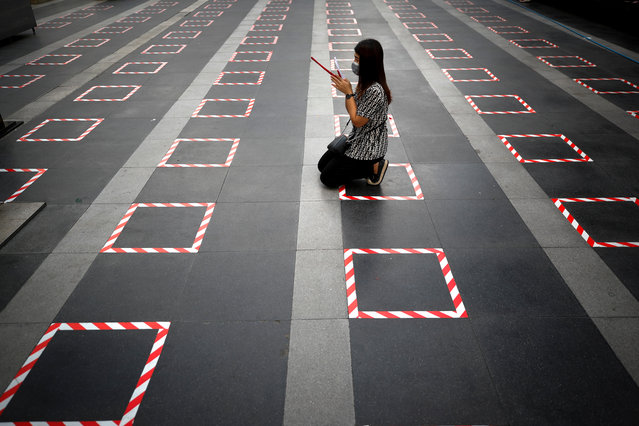 A woman kneels inside a social distancing marker to offer prayers to a Hindu statue of Ganesh, outside a shopping mall in Bangkok, Thailand, 28 December 2020. After months of zero reported local COVID-19 infections, Thailand is now tackling an outbreak with its source tracked to a wholesale shrimp market in Samut Sakhon province, which has seen infections reach 43 provinces. The government has prohibited public New Year celebrations and crowded gatherings in order to help contain the spread of the coronavirus disease (COVID-19) pandemic. (Photo by Diego Azubel/EPA/EFE)