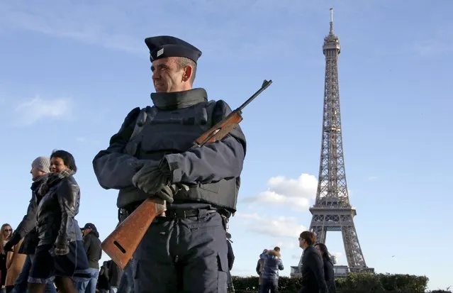 A French police officer stands guard by the Eiffel tower a week after a series of deadly attacks in the French capital Paris, France, November 22, 2015. (Photo by Eric Gaillard/Reuters)