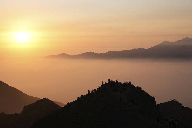 People look out at clouds and fog from Canteria Hill on the outskirts of Lima, Peru, Sunday, July 13, 2025. (Photo by Martin Mejia/AP Photo)