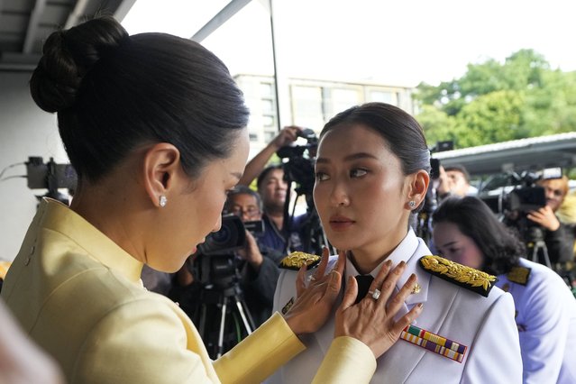 Pinthongta Shinawatra adjusts the collar of her younger sister, Thailand's newly elected Prime Minister Paetongtarn Shinawatra, ahead of the royal endorsement ceremony, in Bangkok, Thailand, August 18, 2024. (Phoot by Sakchai Lalit/AP Photo)