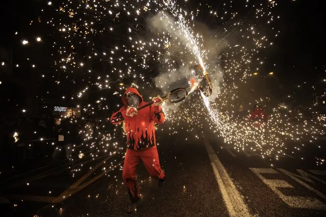 A “demoni” takes part in the “Cabalgata del Foc” ride during the “Nit de la Crema” (Fire Night) in Valencia, eastern Spain, 19 March 2022. The traditional Fallas feast is held in Valencia region annually until 19 March to commemorate Saint Joseph, the patron of carpenters. The Fallas, installations of parodic huge papier-mache, cardboard, and wooden sculptures, are burnt on 19 March in the so-called “Crema” to mark the end the Falles event. (Photo by Biel Alino/EPA/EFE)