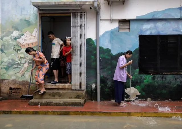 People clean the back-alley of shophouse as the floodwaters recede, in Kota Tinggi, Johor, Malaysia on March 5, 2023. (Photo by Hasnoor Hussain/Reuters)