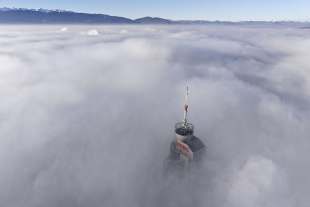 Avaz Twist Tower building, 172 meters high, peaks through a dense layer of fog and smog in Sarajevo, Bosnia, Thursday, December 19, 2024. (Photo by Armin Durgut/AP Photo)