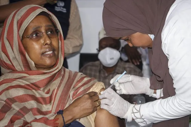 Somalia's Minister of Health Fawziya Abikar Nur, receives a shot of AstraZeneca COVID-19 vaccine, manufactured by the Serum Institute of India and provided through the global COVAX initiative, at a ceremony to mark the start of coronavirus vaccinations in Mogadishu, Somalia Tuesday, March 16, 2021. (Photo by Farah Abdi Warsameh/AP Photo)