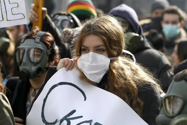 Environmentalists, wearing protective and gas masks, march through a street protesting against the polluted air in Skopje, Macedonia, Sunday, February 1, 2015. A few hundred of environmentalists protested Sunday to raise awareness about air pollution and nature contamination. (Photo by Boris Grdanoski/AP Photo)