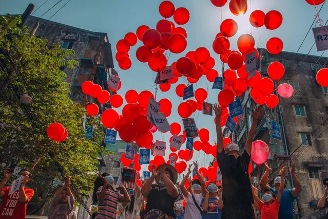 This photo taken and received courtesy of an anonymous source via Facebook on March 22, 2021 show residents setting free balloons with messages relating to “R2P”, or the “Responsibility to Protect” principle that the international community is justified in taking action against a state that is deemed to have failed to protect its population from atrocities, in Yangon's Hlaing township, as security forces continue to crackdown on demonstrations by protesters against the military coup. (Photo by Handout/FACEBOOK via AFP Photo)