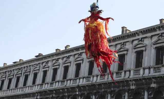 The traditional Columbine descends from Saint Mark's tower bell on an iron cable during the Venetian Carnival in Venice February 8, 2015. (Photo by Stefano Rellandini/Reuters)