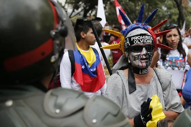 A woman protest in front of national guards during a march against Venezuelan President Nicolas Maduro's government in Caracas February 12, 2015. (Photo by Jorge Silva/Reuters)