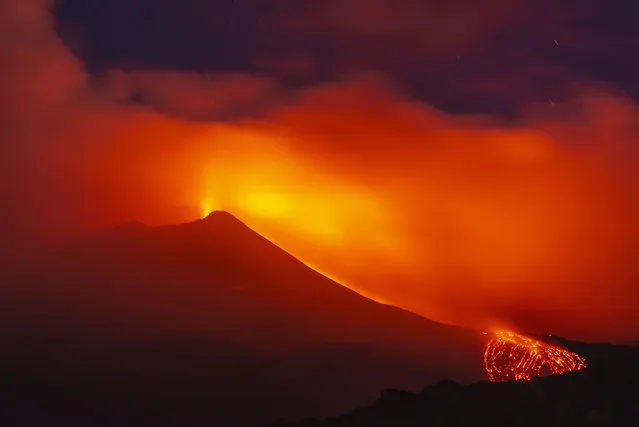 Mount Etna volcano spews lava during an eruption early Saturday, August 25, 2018. Mount Etna in Sicily has roared back into spectacular volcanic action, sending up plumes of ash and spewing lava. Italy's National Institute of Geophysics and Vulcanology (INGV) says that the volcano, which initially “re-awoke” in late July, sprang into fuller action Thursday evening by shooting up chunks of flaming lava as high as 150 meters (500 feet) almost constantly. (Photo by Salvatore Allegra/AP Photo)