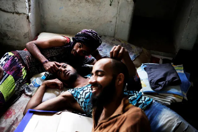Rodrigo (R), 26, Wam (C), 24, and Teflon, 19, members of the lesbian, gay, bisexual and transgender (LGBT) community who have been invited to live in a building that the roofless movement has occupied, relax in downtown Sao Paulo, Brazil, November 8, 2016. (Photo by Nacho Doce/Reuters)