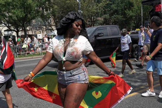 A woman dances with the national flag of Grenada during the annual West Indian American Day parade in the Brooklyn borough of New York City, New York, U.S., September 4, 2023. (Photo by Bing Guan/Reuters)