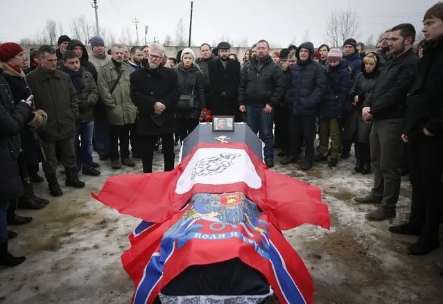 People gather around a coffin bearing the body of Evgeniy Pavlenko, during his funeral in St.Petersburg February 21, 2015. Pavlenko, 36, a former teacher, joined the armed forces of the separatist self-proclaimed Donetsk People's Republic and was killed during recent fighting with the Ukrainian armed forces near Debaltseve, eastern Ukraine. REUTERS/Maxim Zmeyev  (RUSSIA - Tags: POLITICS CIVIL UNREST OBITUARY TPX IMAGES OF THE DAY)