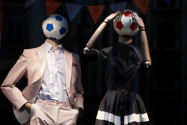 Mannequins with soccer balls as heads to mark the upcoming 2018 FIFA World Cup in Russia, are displayed on a showcase of a clothing store in downtown Malaga, Spain on June 8, 2018. (Photo by Jon Nazca/Reuters)