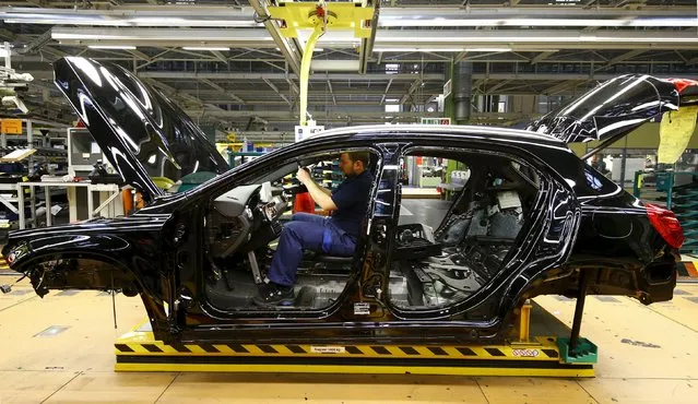 An employee of German car manufacturer Mercedes Benz works on the interior of a GLA model at their production line at the factory in Rastatt, Germany, January 22, 2016. (Photo by Kai Pfaffenbach/Reuters)