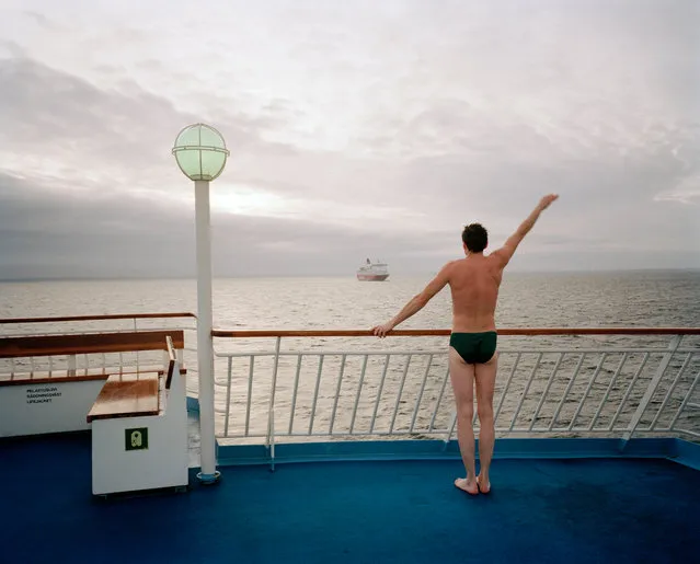 Ferry between Helsinki and Stockholm, 1991, by Martin Parr. “In the early 80s, I was teaching in Helsinki and would often go to Stockholm for the weekend on the ferry. This would involve buying cheap alcohol and consuming it en route. The Finnish love a sauna, and this guy is popping out to catch the cool”. (Photo by Martin Parr/Magnum Photos)