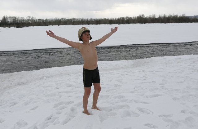 Pyotr Syomin, a 11-year-old member of a winter swimmers family club, practices yoga after swimming in the icy waters of the Tuba river in the Kuragino village, southeast of the Russian Siberian city of Krasnoyarsk, March 17, 2015. (Photo by Ilya Naymushin/Reuters)