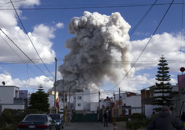 A massive explosion guts Mexico's biggest fireworks market in Tultepec, on December 20, 2016. The explosion killed at least 31 people and injured 72, authorities said. The conflagration in the Mexico City suburb of Tultepec set off a quick-fire series of multicolored blasts that sent a vast cloud of smoke billowing over the capital. (Photo by Israel Gutierrez/AFP Photo)