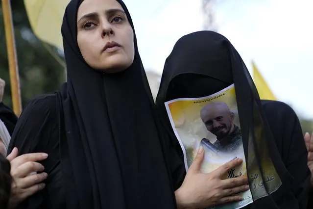 The wife, left, and sister of Hezbollah fighter Ali Ftouni, who was killed by Israeli shelling, mourn at his funeral procession in Kherbet Selem village, south Lebanon, Tuesday, October 10, 2023. The Iran-backed group Monday night announced that three militants died following heavy Israeli shelling in border towns across southern Lebanon. (Photo by Hussein Malla/AP Photo)