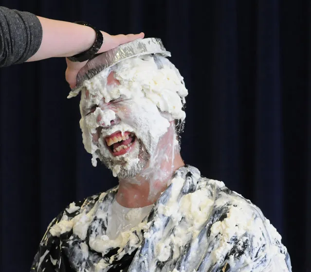 Jamie Campbell, principal at Crabbe Elementary School, reacts as another whipped-cream pie smacks his head during a celebration of the 100th day of school in Ashland, Ky., Monday, February 1, 2016. (Photo by Kevin Goldy/The Daily Independent via AP Photo)
