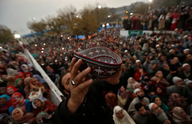 A Muslim raises his cap upon seeing a relic, believed to be hair from the beard of the prophet Mohammad, being displayed during the festival of Eid-e-Milad-ul-Nabi, the birth anniversary of the prophet, at Hazratbal shrine in Srinagar November 21, 2018. (Photo by Danish Ismail/Reuters)