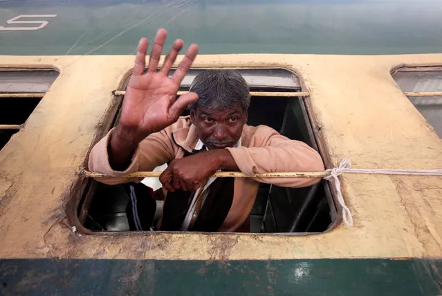 A fisherman from India waves from a window of a train, after he was released with others from a prison, at Cantonment railway station in Karachi, Pakistan, December 25, 2016. (Photo by Akhtar Soomro/Reuters)
