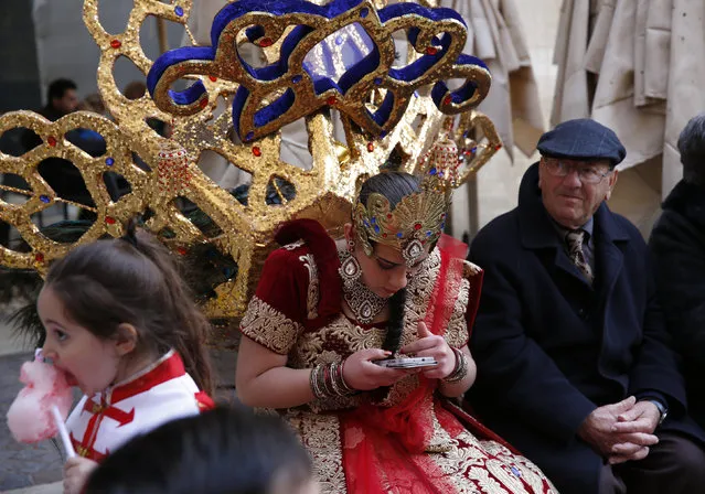 A carnival dancer uses her mobile device as she sits next to onlookers during carnival celebrations in Valletta, Malta, February 7, 2016. (Photo by Darrin Zammit Lupi/Reuters)