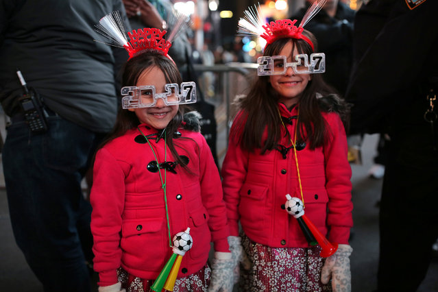 Twin revelers Abby Phillips, 6, (R), and Penny Phillips, 6, in Times Square for the New Year's celebration in Manhattan, New York City, U.S., December 31, 2016. (Photo by Stephen Yang/Reuters)