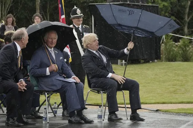 Britain's Prince Charles, centre, and Prime Minister Boris Johnson, right, shelter from rain during the unveiling of the UK Police Memorial at the National Memorial Arboretum at Alrewas, England, Wednesday July 28, 2021. The memorial commemorates all personnel who have lost their lives since the 1749 formation of the original police force, the Bow Street Runners. (Photo by Christopher Furlong/Pool via AP Photo)