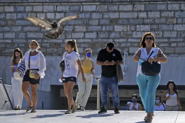 Commuters exit from Syntagma Metro station in Athens, Tuesday, August 24, 2021. Greece's health minister is announcing new measures for the non-vaccinated, as the number of COVID-19 cases and hospitalizations continue to rise. (Photo by Thanassis Stavrakis/AP Photo)