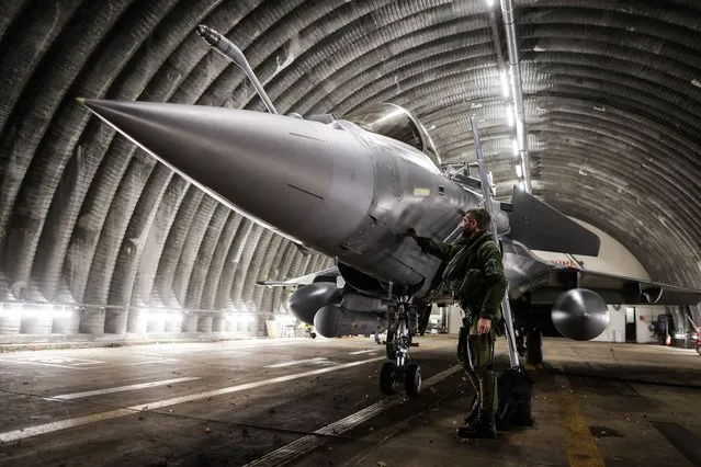 A Rafale jet fighter pilot checks and prepares his aircraft before leaving for a four-month mission to protect the airspace of the Baltic States, as France is deploying four Rafale fighters to Lithuania under NATO mandate, from BA 118 in Mont-de-Marsan, southwestern France, on November 25, 2022. (Photo by Thibaud Moritz/AFP Photo)