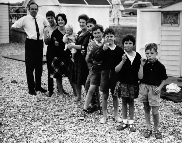 Dr. Michael Ash, 44-year-old British medical specialist, on the beach at Bexhill, England on September 7, 1962 supplies his family with Strontium-87 lollipops which he says can combat radioactive fallout. Immunization he says is accomplished with the sugar sweetened and flavored strontium lollipops made of seaweed and strontium rock found near Chipping Sodbury where Britain's leukemia rate is lowest. Ash, with him from left to righ: David, 14, who helps make the lollipops; Jennifer, 16; Mrs. Ash with Richard, 1; Timothy, 15; Simon, 12; Stephen, 11; Mary, 9 and Peter 7. (Photo by AP Photo)
