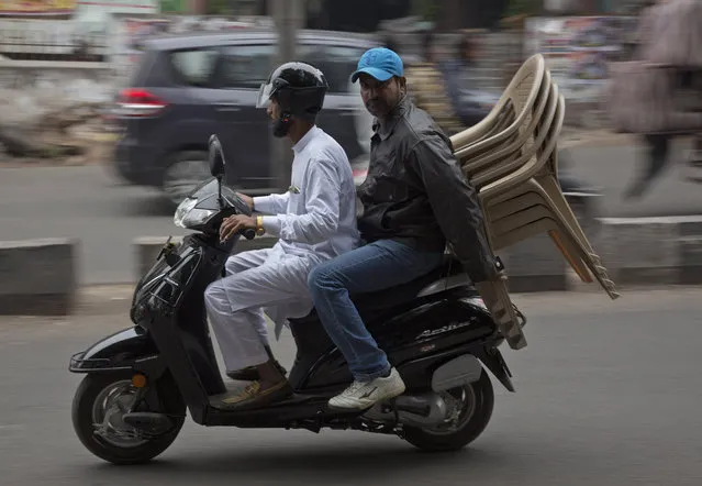 In this December 17, 2018, photo, two men transport chairs purchased from a shop at the Nampally furniture market in Hyderabad, India. Such furniture markets, where customers haggle over prices and work with carpenters to design made-to-order housewares, is the competition Swedish giant Ikea faces in tackling the $40 billion Indian market for home furnishings, which is growing quickly along with the country’s consumer class. Ikea declined to break out India revenues, but Forrester Researcher analyst Satish Meena said that within five years the company hopes to capture $4 billion annually _ or 10 percent of India’s furniture and home goods market. (Photo by Mahesh Kumar A./AP Photo)