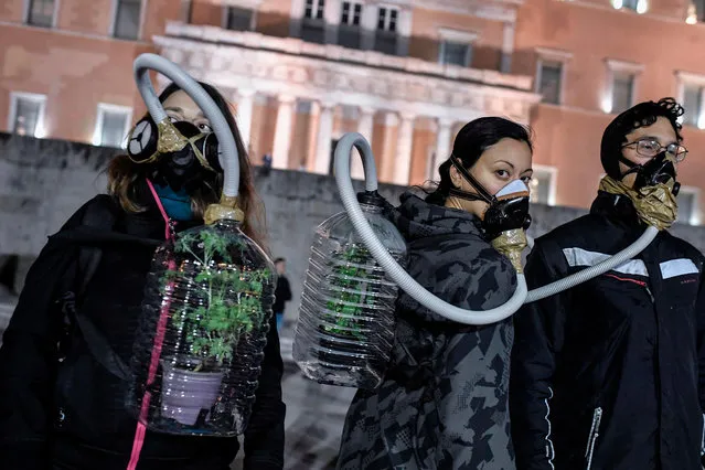 Environmental activists wearing masks protest in front of the Greek parliament in central Athens during a demonstration against hydrocarbon exploration and drilling in the Greek seas on February 21, 2019. Since the wake of the economic crisis, cash strapped Greece has promoted oil and gas as the spearhead of its economic recovery strategy.Environmental groups claim burning fossil fuels is the main cause of climate change and oil drilling causes severe impacts on the areas of concern and undermines the potential of local economies for sustainable development. (Photo by Louisa Gouliamaki/AFP Photo)