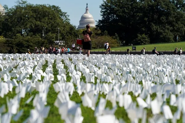 People view thousands of white flags representing Americans who have died of the coronavirus disease (COVID-19) placed over 20 acres of the National Mall in Washington, U.S., September 26, 2021. (Photo by Joshua Roberts/Reuters)