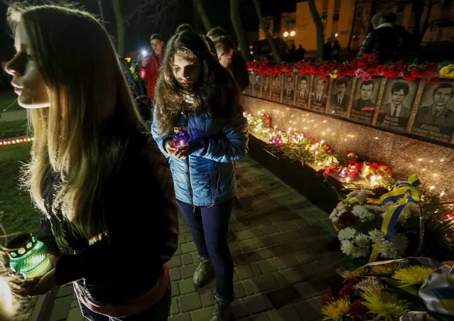 People hold lit candles as they take part in a commemoration ceremony at a memorial, dedicated to firefighters and workers who died after the Chernobyl nuclear disaster, during a night service near the Chernobyl plant in the city of Slavutych, Ukraine, April 25, 2015. Belarus, Ukraine and Russia marked the 29th anniversary of the Chernobyl disaster, the world's worst civil nuclear accident. (Photo by Gleb Garanich/Reuters)
